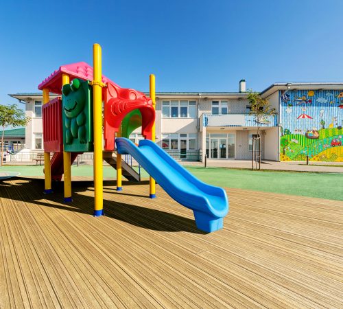 Preschool building exterior with playground on a sunny day